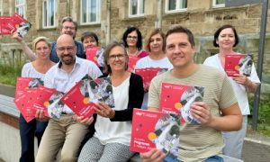 Mitarbeiter der VHS Recklinghausen mit dem Programmheft des 2. Halbjahres 2024 in den Händen